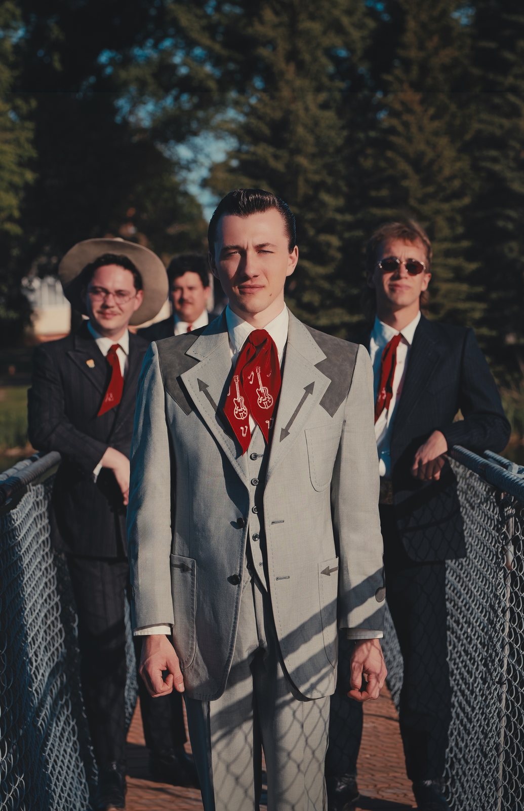 Jake Vaadeland in a grey western suit with The Sturgeon River Boys behind him