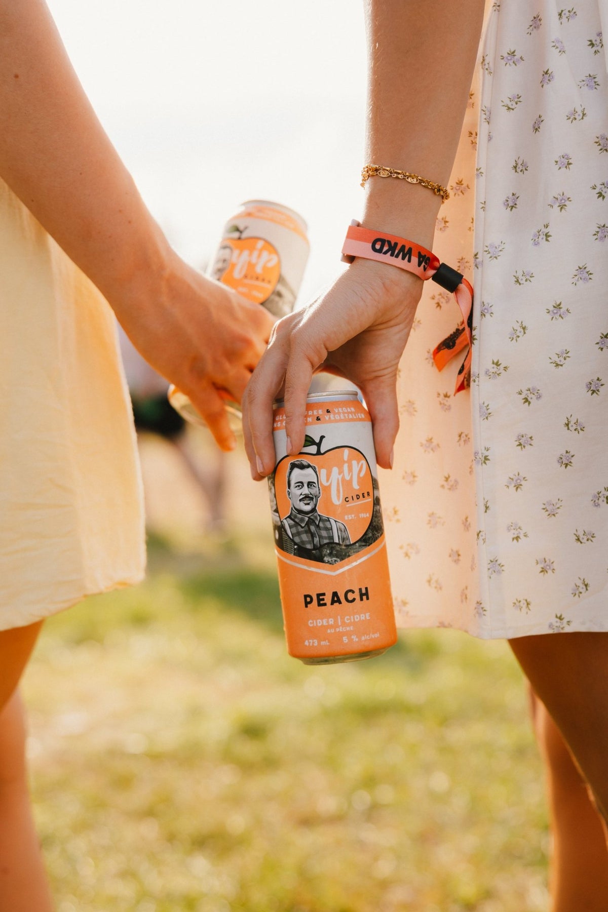 Close-up of a hand holding a can of Yip Peach in warm evening light