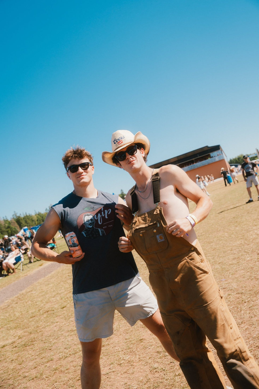 Two friends at Cavendish Beach Music Festival, one in a Yip Cider shirt holding a can of Peach